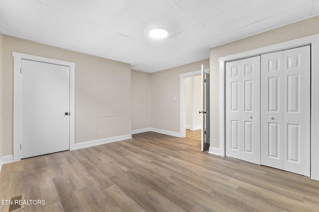 unfurnished bedroom with a closet and light hardwood / wood-style flooring