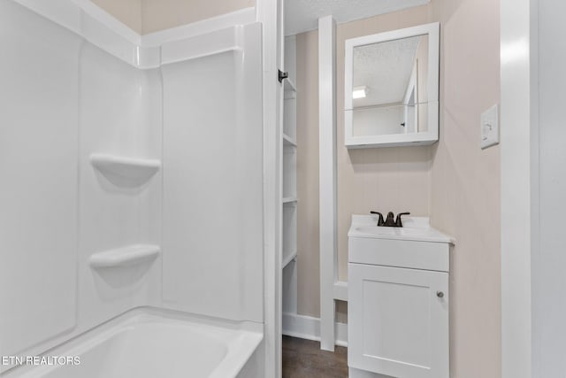 bathroom with vanity, a textured ceiling, and bathing tub / shower combination