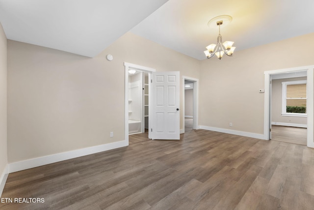 unfurnished room with dark hardwood / wood-style flooring and a notable chandelier