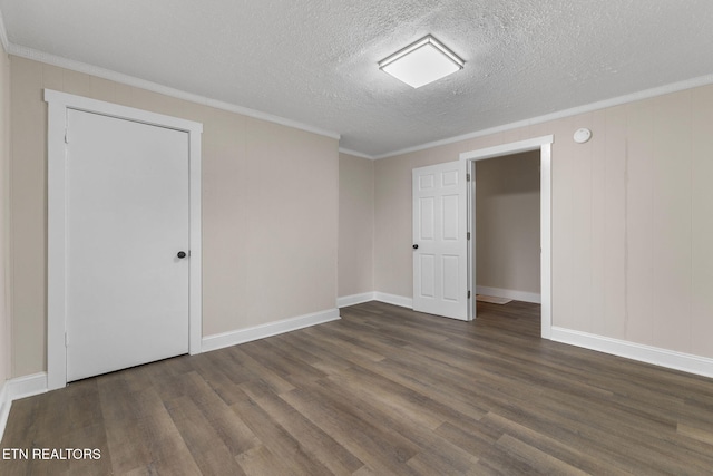 unfurnished room featuring a textured ceiling, dark hardwood / wood-style flooring, and crown molding