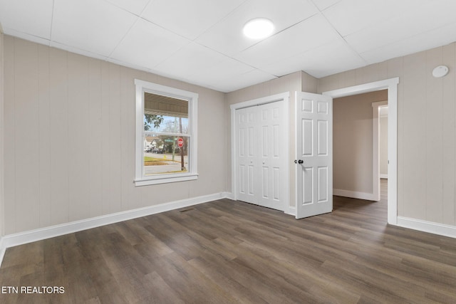 unfurnished bedroom featuring a closet and dark wood-type flooring