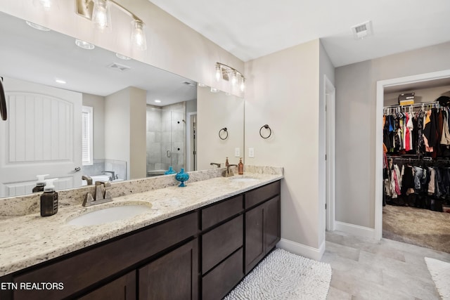 bathroom with a shower with door and vanity