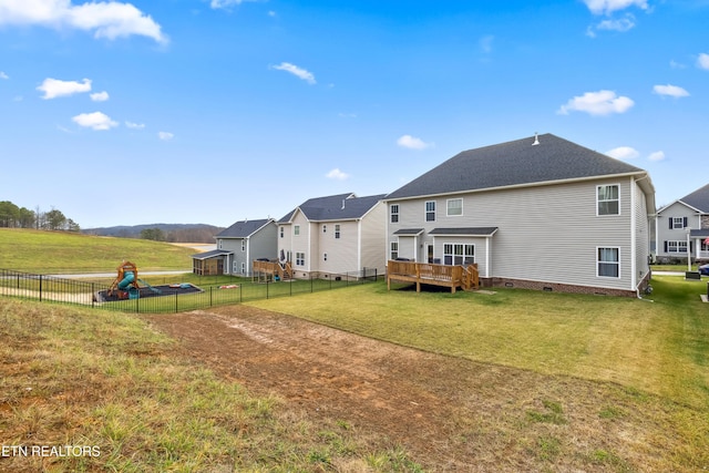 rear view of house featuring a lawn and a deck