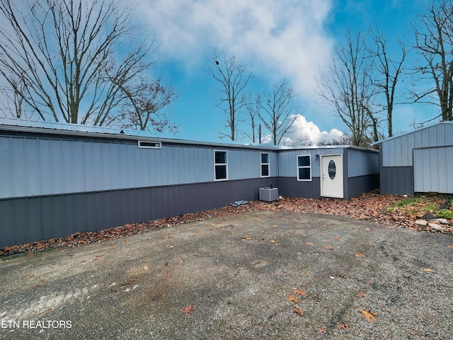 rear view of property with central AC