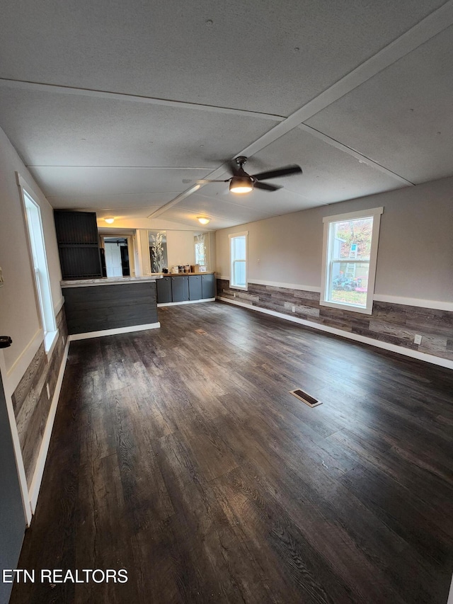 unfurnished living room featuring dark hardwood / wood-style floors and ceiling fan