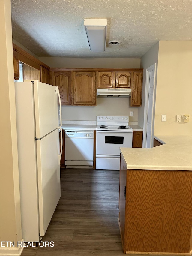 kitchen featuring dark hardwood / wood-style floors, a textured ceiling, and white appliances