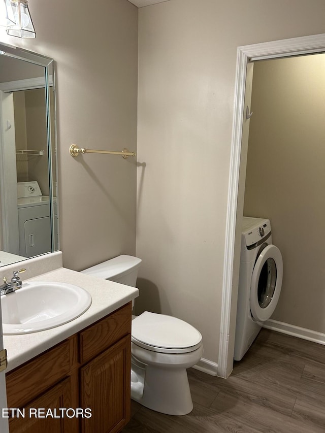 bathroom with vanity, washer / clothes dryer, hardwood / wood-style flooring, and toilet