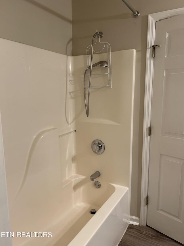 bathroom with wood-type flooring and bathing tub / shower combination