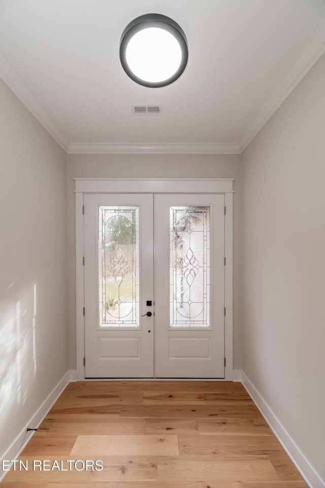 entryway featuring light wood finished floors, visible vents, baseboards, and ornamental molding