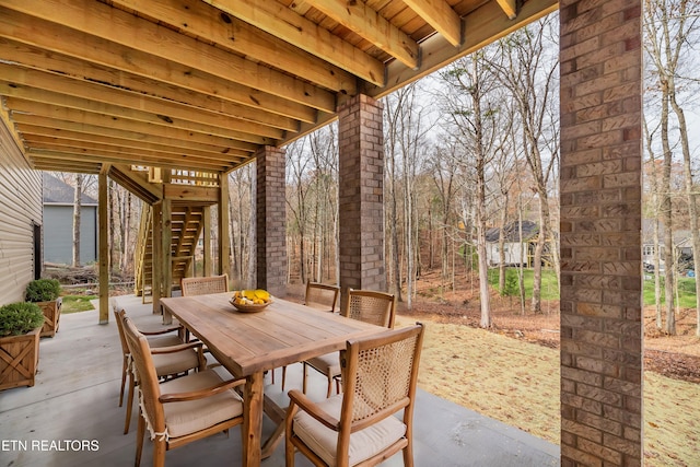 view of patio with outdoor dining space and stairs