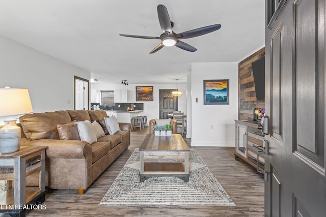 living room featuring ceiling fan and dark hardwood / wood-style floors