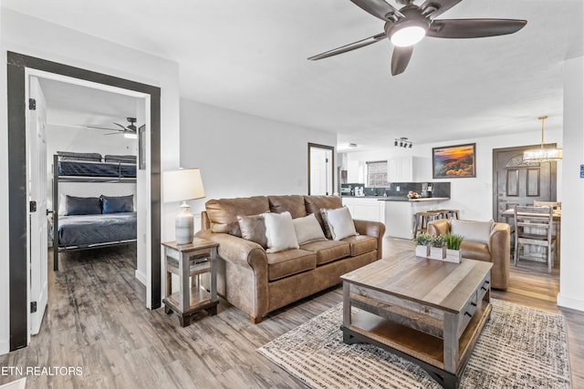 living room with a notable chandelier and light wood-type flooring