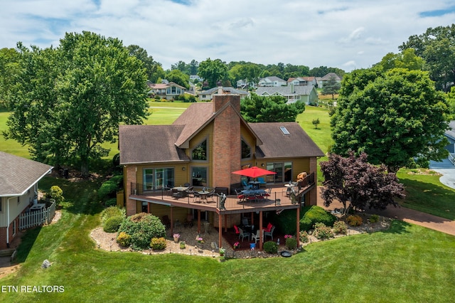 back of property featuring a yard and a wooden deck