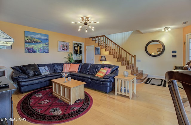 living room with an inviting chandelier and light hardwood / wood-style flooring