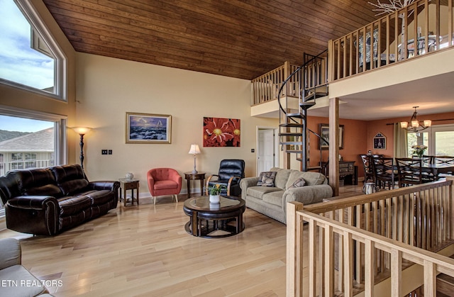 living room with wooden ceiling, a chandelier, a towering ceiling, and light hardwood / wood-style flooring