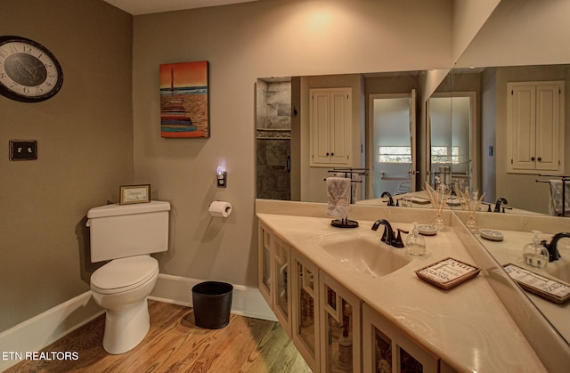 bathroom featuring wood-type flooring, vanity, and toilet