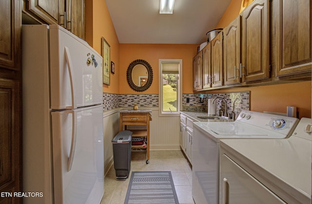 washroom featuring sink, light tile patterned floors, and independent washer and dryer