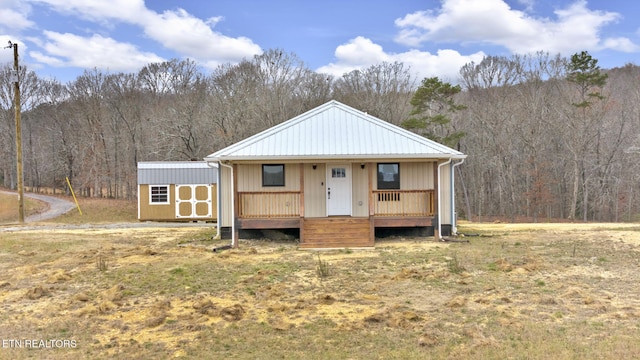 view of front of property with a porch and a shed