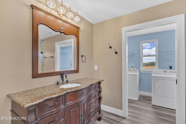 bathroom featuring hardwood / wood-style floors, vanity, and washing machine and clothes dryer