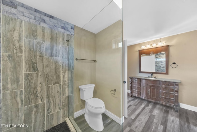 bathroom with a shower, hardwood / wood-style floors, vanity, and toilet