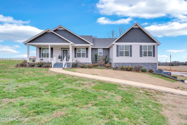 craftsman inspired home with a porch and a front yard