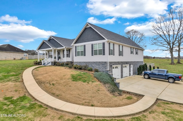 view of front of house with covered porch, a front yard, and a garage