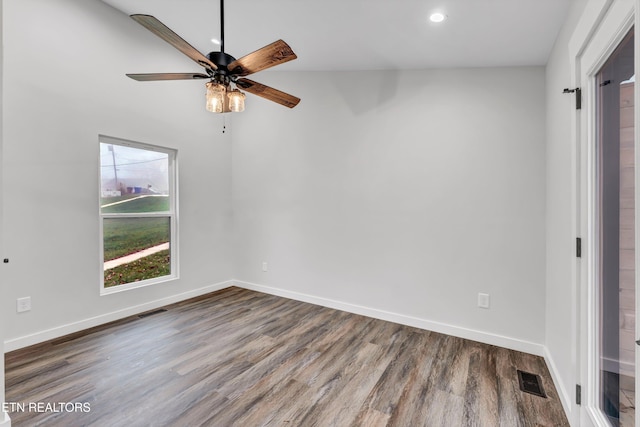 unfurnished room featuring vaulted ceiling, ceiling fan, and dark hardwood / wood-style floors