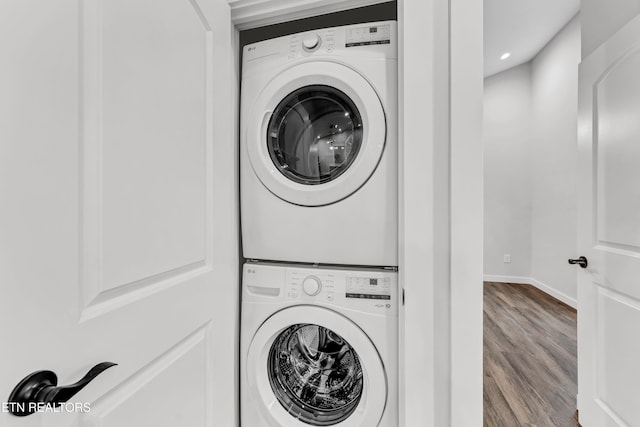 clothes washing area with stacked washer / dryer and light hardwood / wood-style flooring