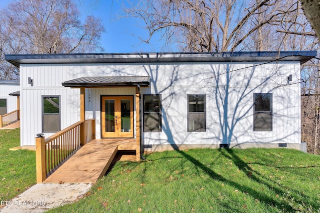 rear view of property with french doors and a yard