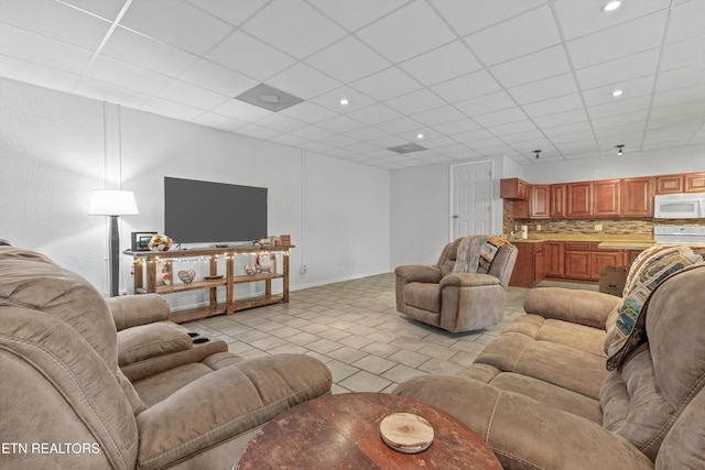 living room featuring a paneled ceiling and light tile patterned flooring