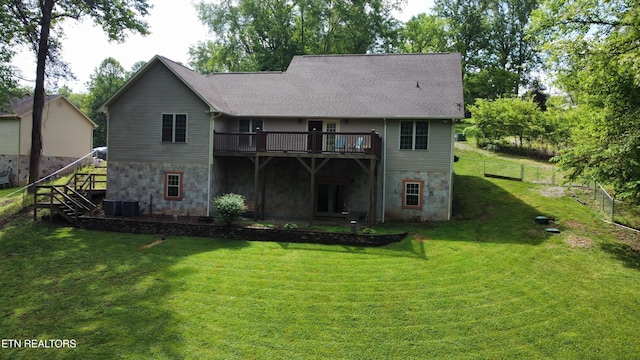 rear view of house featuring a lawn, stairway, a wooden deck, and stone siding