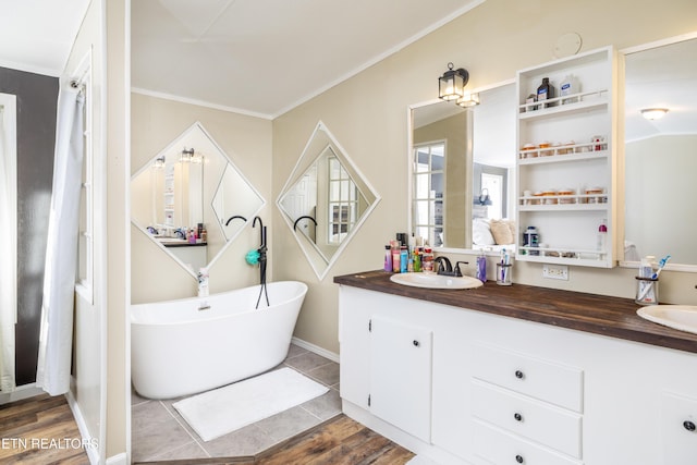 bathroom featuring a washtub, vanity, hardwood / wood-style floors, and ornamental molding