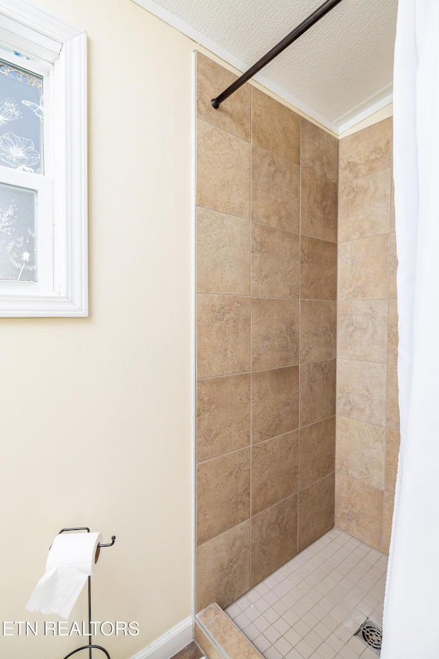 bathroom featuring a shower with shower curtain and a textured ceiling