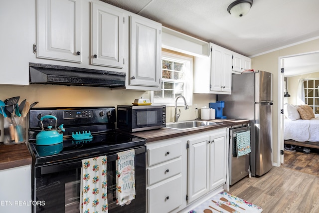 kitchen with white cabinetry, sink, wood counters, black appliances, and light wood-type flooring