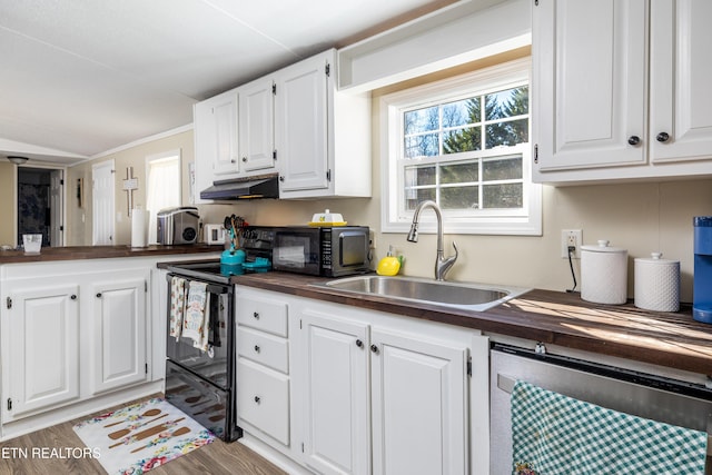 kitchen featuring white cabinets, wooden counters, beverage cooler, and sink