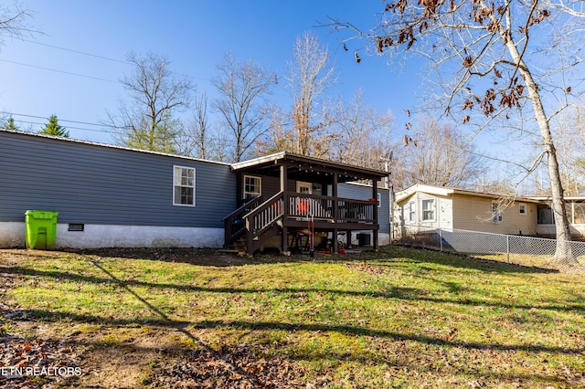 back of house with a deck and a lawn