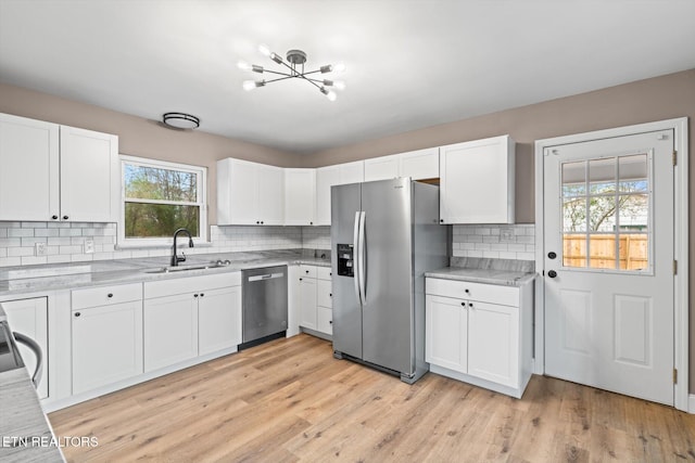 kitchen with white cabinetry, sink, stainless steel appliances, and plenty of natural light