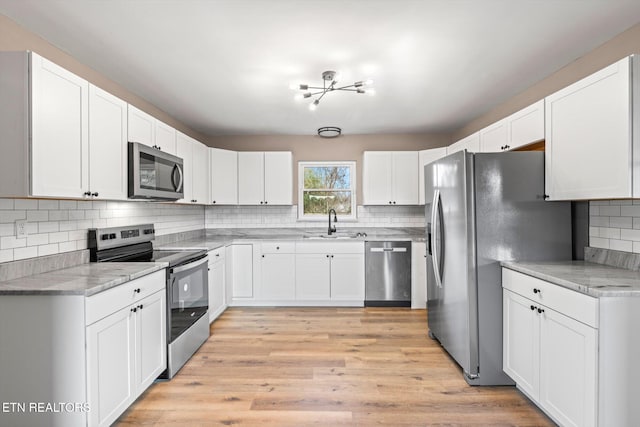 kitchen featuring light hardwood / wood-style floors, white cabinetry, sink, and appliances with stainless steel finishes