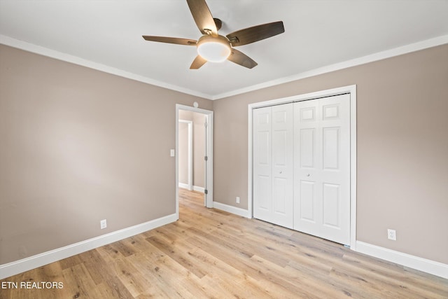 unfurnished bedroom featuring light hardwood / wood-style floors, a closet, crown molding, and ceiling fan