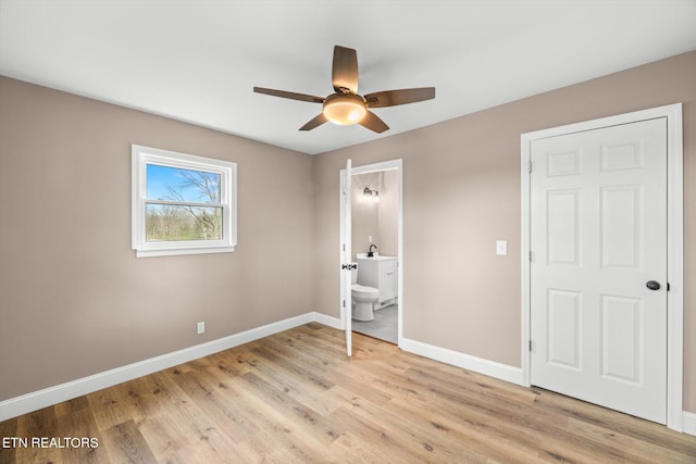 unfurnished bedroom with ceiling fan, light hardwood / wood-style flooring, ensuite bathroom, and sink