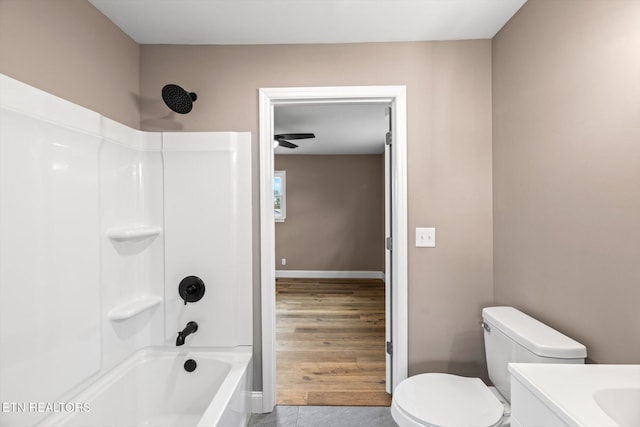 full bathroom with hardwood / wood-style floors, vanity,  shower combination, and toilet