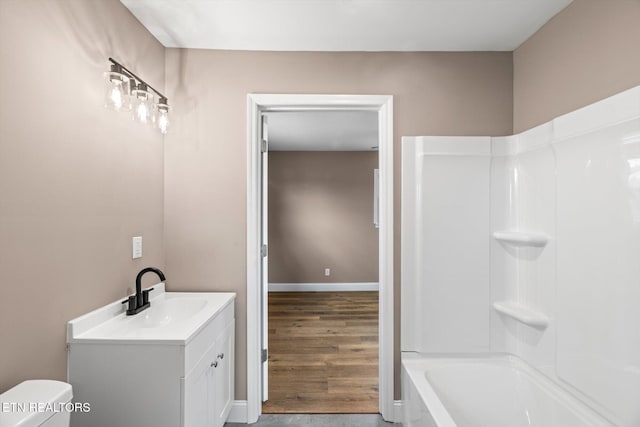 full bathroom with hardwood / wood-style floors, vanity, toilet, and shower / washtub combination