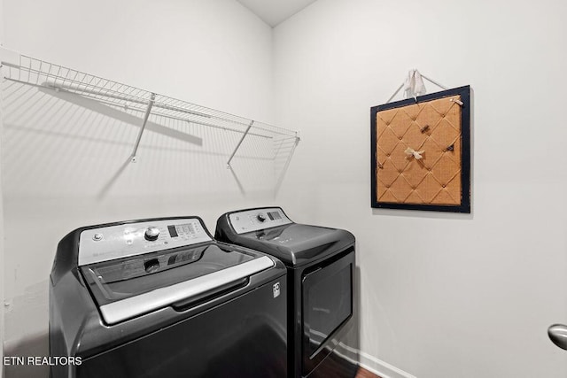 washroom featuring washing machine and clothes dryer and wood-type flooring