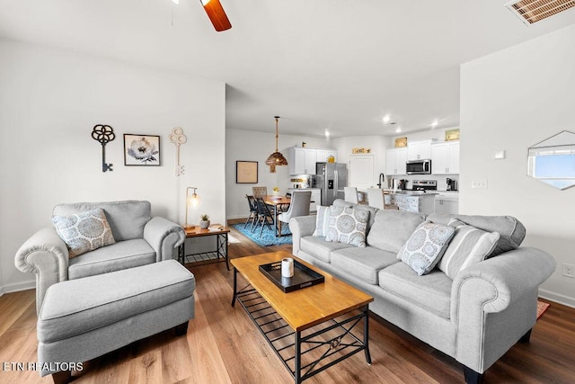 living room featuring ceiling fan and hardwood / wood-style floors