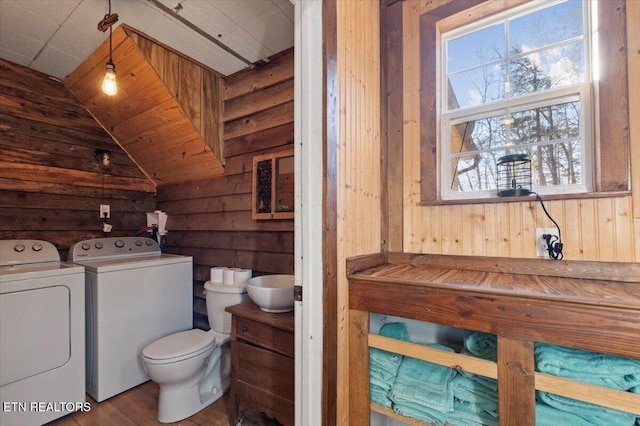 291 Marina Ln, Lafollette, TN 37766 - bathroom featuring independent washer and dryer, wood walls, hardwood / wood-style floors, lofted ceiling, and toilet