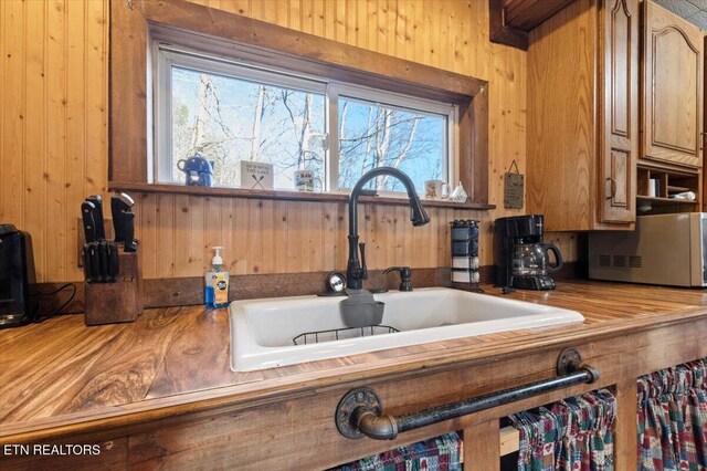 291 Marina Ln, Lafollette, TN 37766 - kitchen featuring wooden walls, sink, and a healthy amount of sunlight
