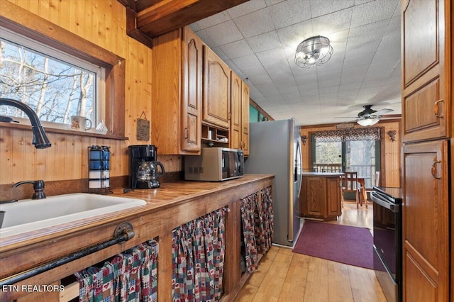 291 Marina Ln, Lafollette, TN 37766 - kitchen with stainless steel appliances, ceiling fan, wood walls, and sink
