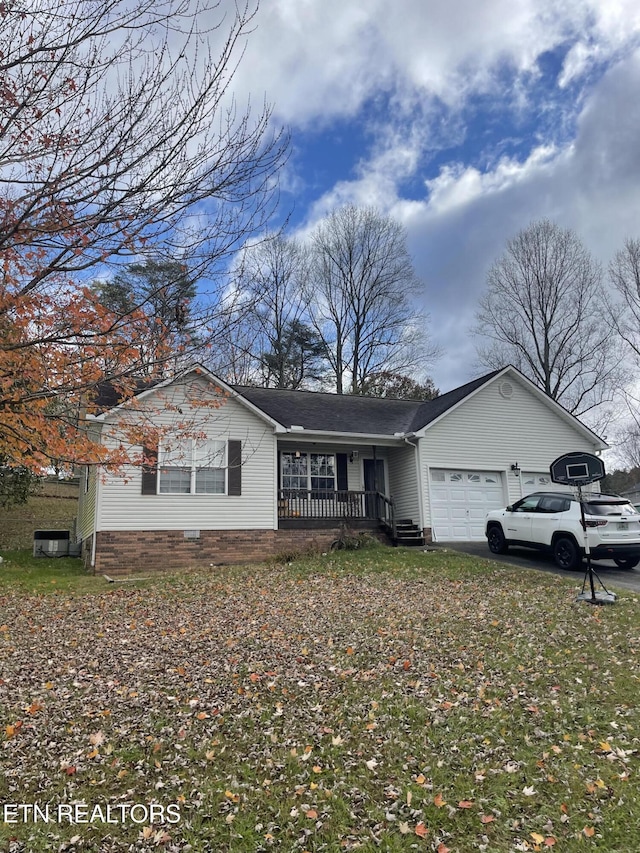 single story home featuring covered porch and a garage