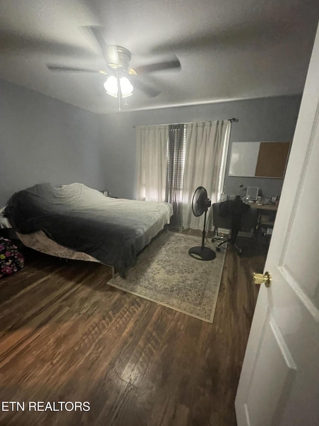 bedroom with dark hardwood / wood-style flooring and ceiling fan