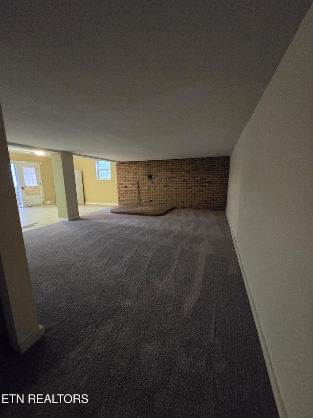 basement with baseboards, a healthy amount of sunlight, and carpet floors